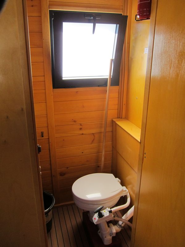 Die WC-Kabine mit fester Toilette mit Handpumpe
