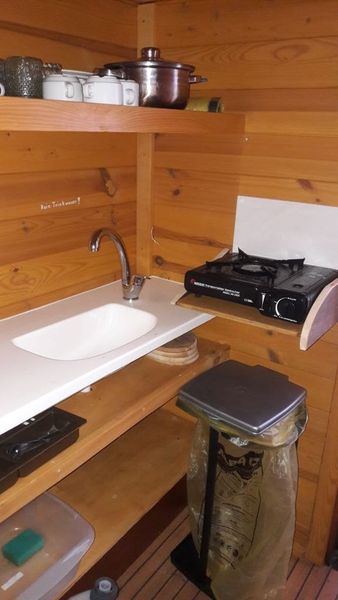 Das Küchenregal mit Campinggaskocher und kleiner Spüle.